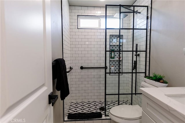 bathroom featuring toilet, a stall shower, and vanity