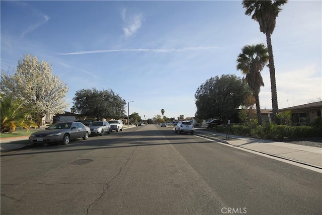 view of road with sidewalks, curbs, and street lights