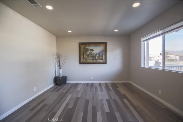 spare room featuring recessed lighting, visible vents, baseboards, and dark wood-type flooring