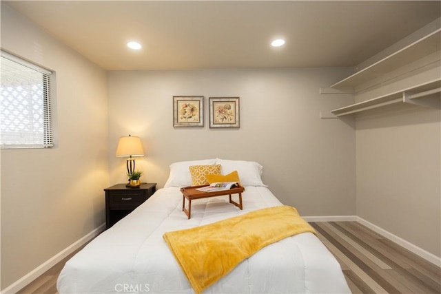 bedroom with recessed lighting, baseboards, and wood finished floors