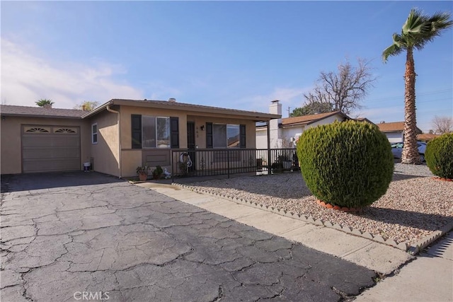 view of front of house with stucco siding, a garage, and driveway