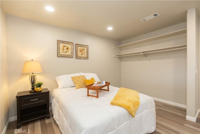 bedroom featuring recessed lighting, visible vents, baseboards, and wood finished floors