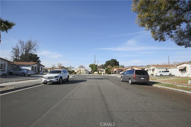 view of street with curbs, sidewalks, and a residential view