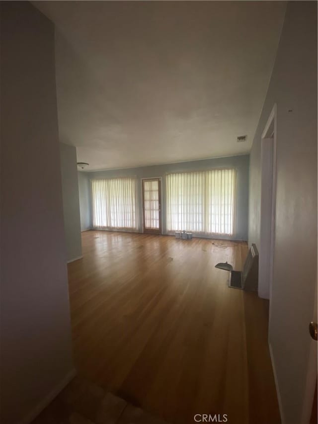 spare room with wood finished floors and visible vents