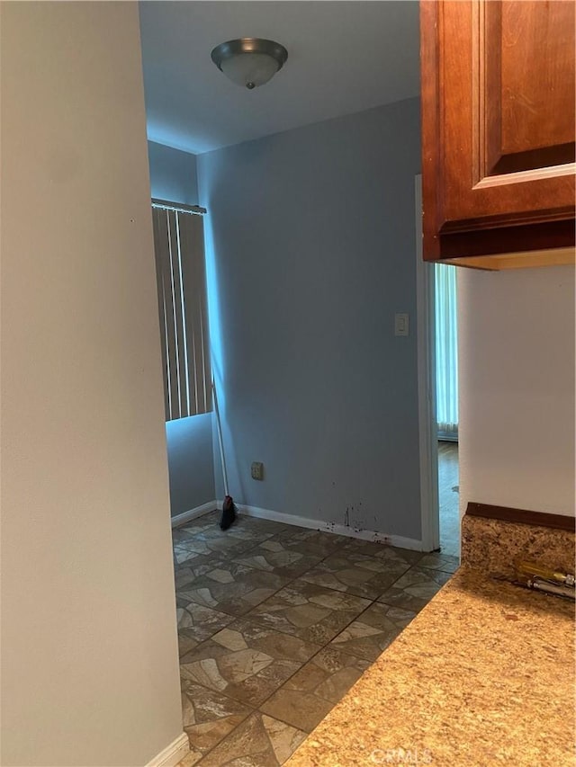 interior space featuring baseboards and stone finish floor