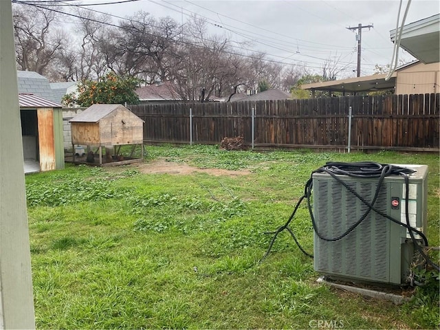 view of yard featuring an outbuilding, central AC unit, exterior structure, and fence