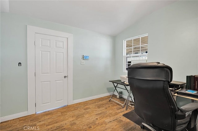 office area with baseboards, wood finished floors, and vaulted ceiling