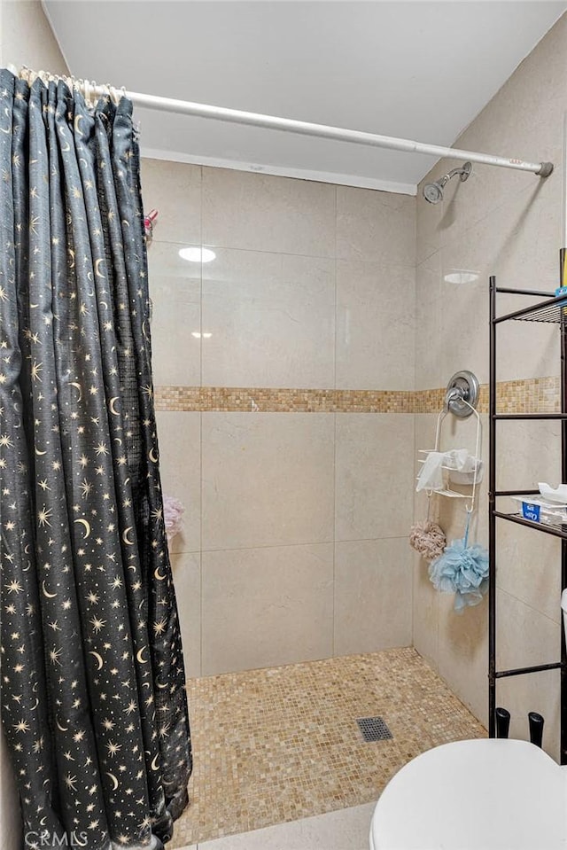 full bath featuring toilet and a tile shower