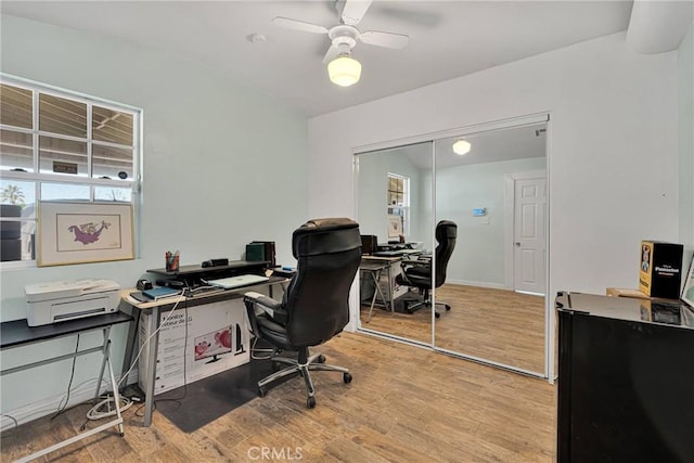 home office with baseboards, wood finished floors, and a ceiling fan