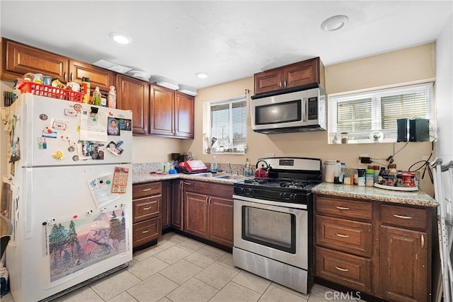 kitchen with light countertops, recessed lighting, appliances with stainless steel finishes, light tile patterned flooring, and a sink