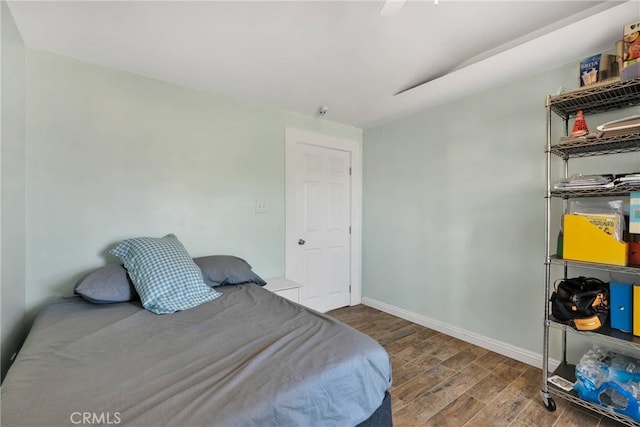 bedroom with wood finished floors, baseboards, and ceiling fan