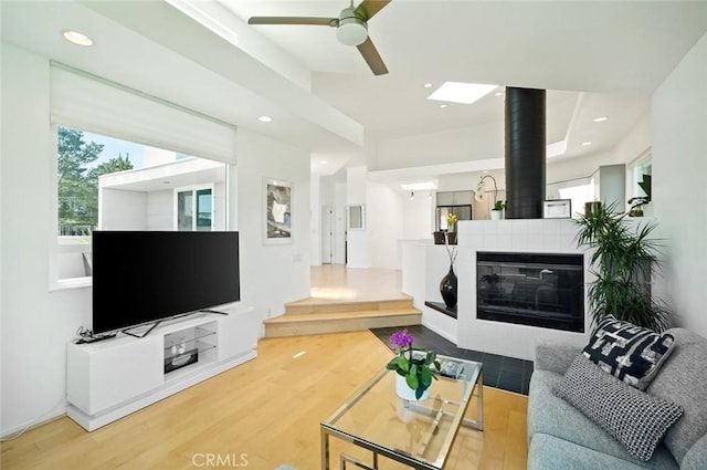 living area featuring a ceiling fan, recessed lighting, wood finished floors, and a fireplace