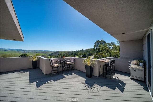 wooden terrace with a mountain view and a grill