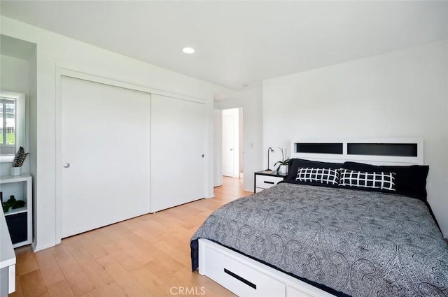 bedroom with a closet, recessed lighting, and light wood-type flooring