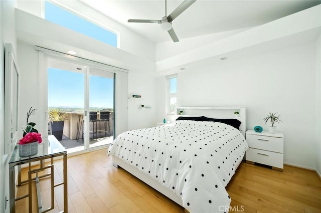 bedroom featuring light wood-style flooring, multiple windows, and access to exterior