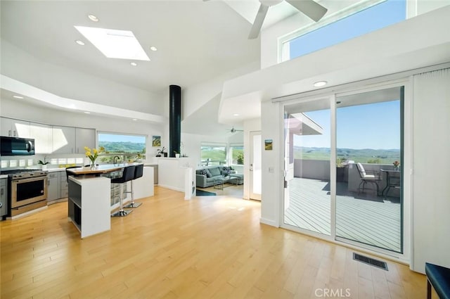 1735 Spencer St, Cambria, CA 93428 - kitchen with stainless steel appliances, a breakfast bar, a high ceiling, ceiling fan, and a kitchen island