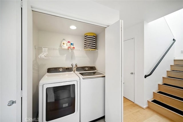 washroom with laundry area, light wood-type flooring, and washing machine and clothes dryer