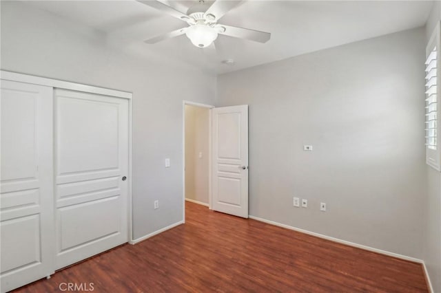 unfurnished bedroom with a closet, a ceiling fan, baseboards, and wood finished floors