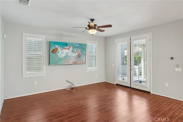 spare room with visible vents, a ceiling fan, wood finished floors, french doors, and baseboards