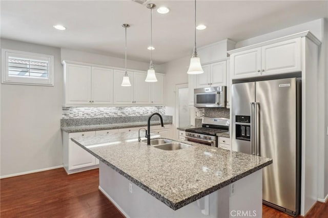 kitchen featuring dark wood finished floors, white cabinets, appliances with stainless steel finishes, and a sink