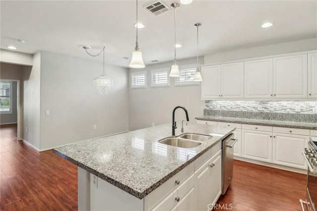 kitchen with visible vents, backsplash, appliances with stainless steel finishes, dark wood-style floors, and a sink