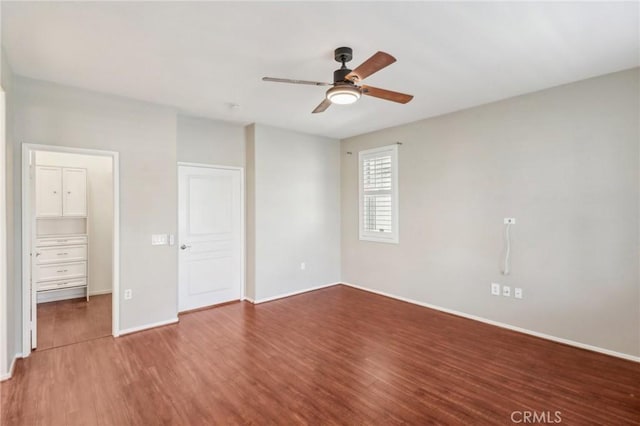 unfurnished bedroom with ceiling fan, a closet, baseboards, and wood finished floors