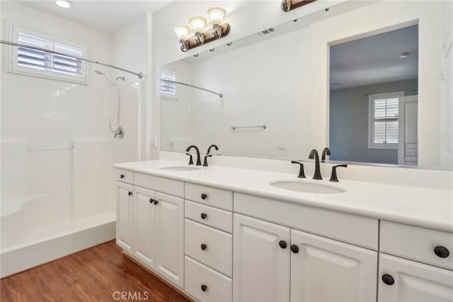 full bath with a wealth of natural light, a shower, and a sink