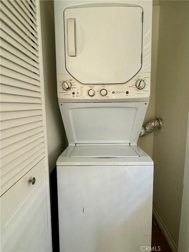 clothes washing area with laundry area and stacked washer / drying machine