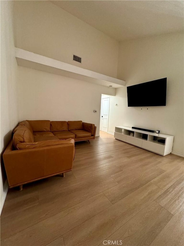 living area with a high ceiling and wood finished floors