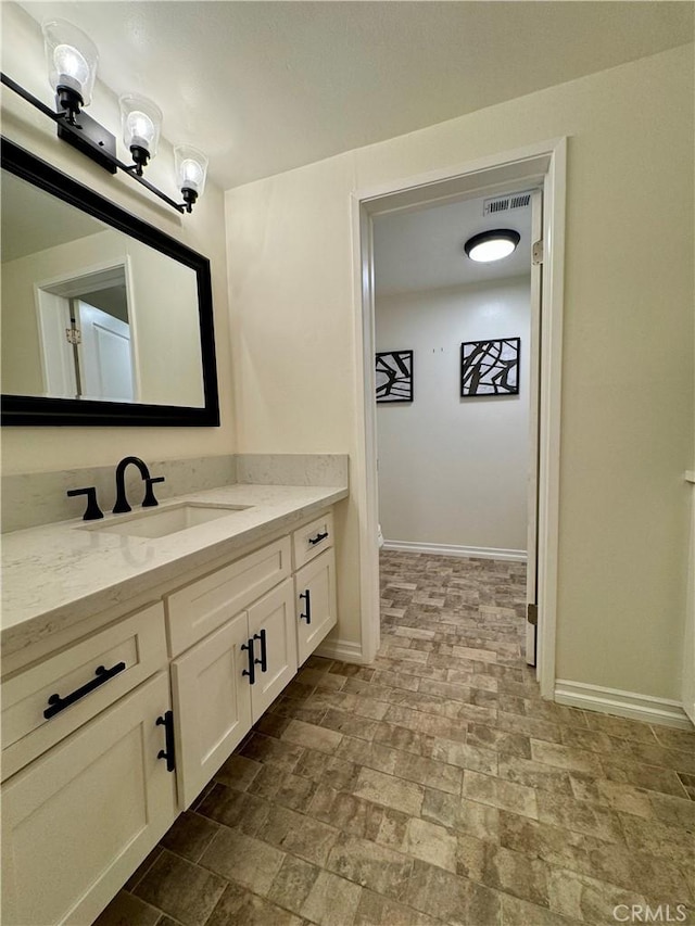 bathroom with visible vents, baseboards, and vanity