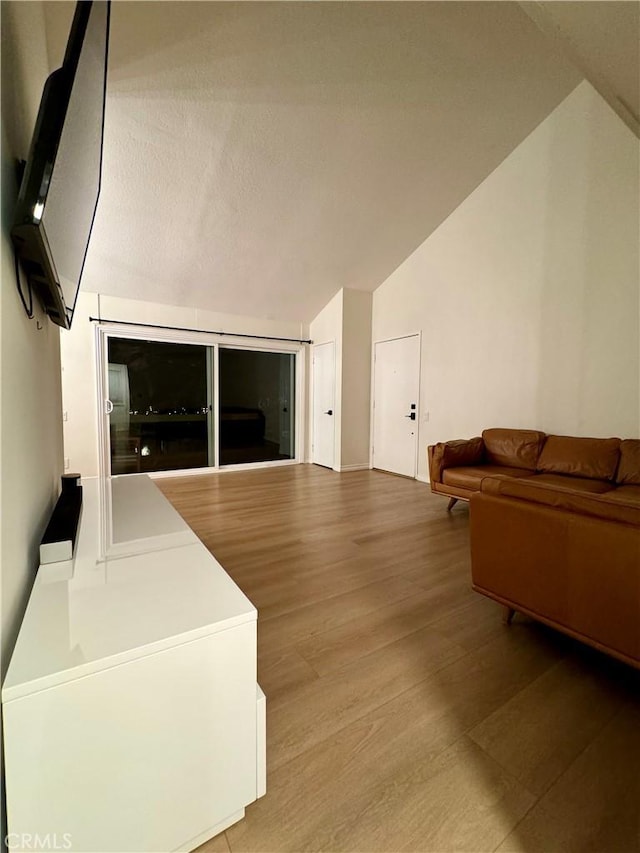 living area featuring light wood-style flooring and lofted ceiling