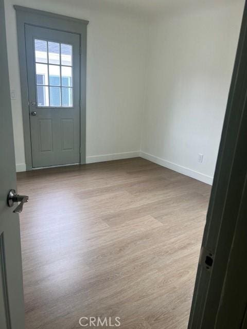 spare room featuring baseboards and wood finished floors