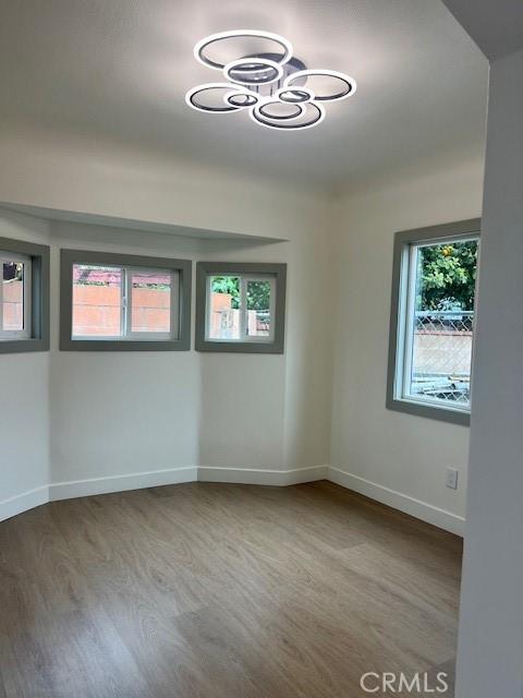 spare room featuring baseboards and wood finished floors