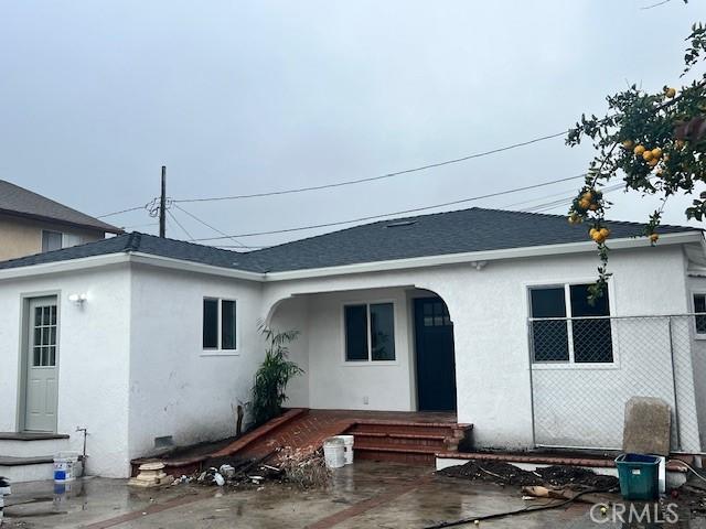 rear view of property with crawl space, stucco siding, entry steps, and a shingled roof