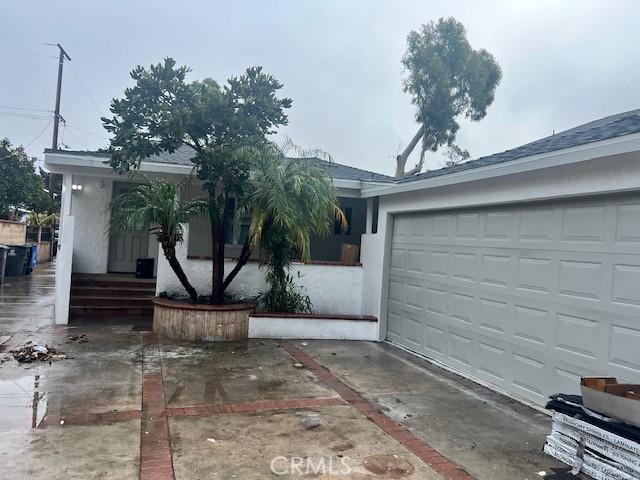 ranch-style house featuring stucco siding and concrete driveway