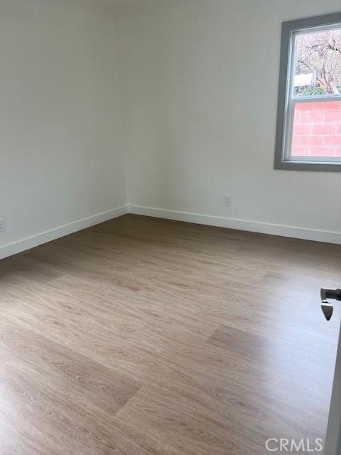 unfurnished room featuring baseboards and wood finished floors