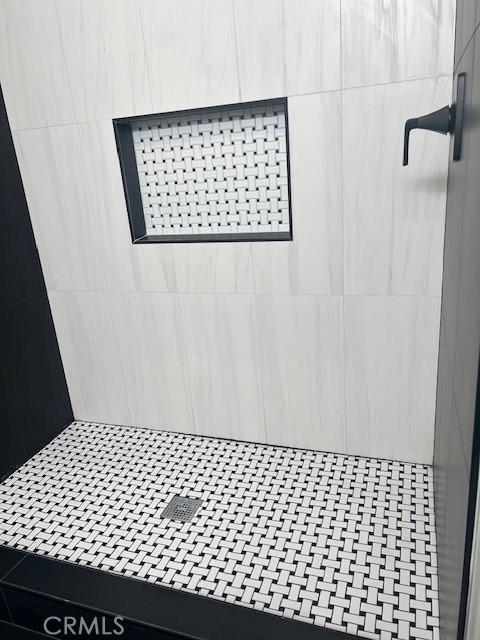 interior details with a tile shower