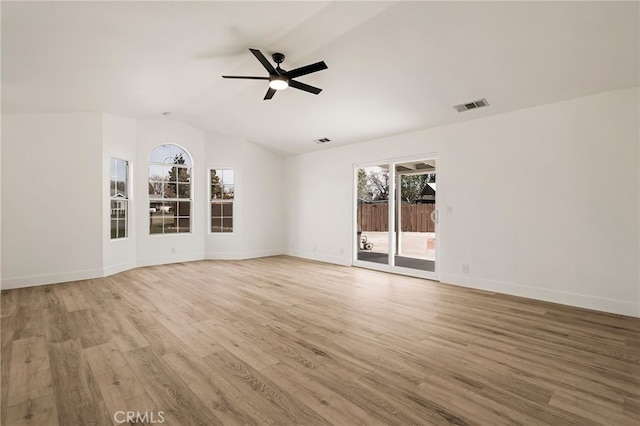 unfurnished room featuring light wood-type flooring, visible vents, baseboards, ceiling fan, and vaulted ceiling