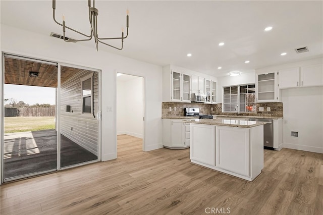 kitchen featuring light wood-style floors, visible vents, backsplash, and appliances with stainless steel finishes