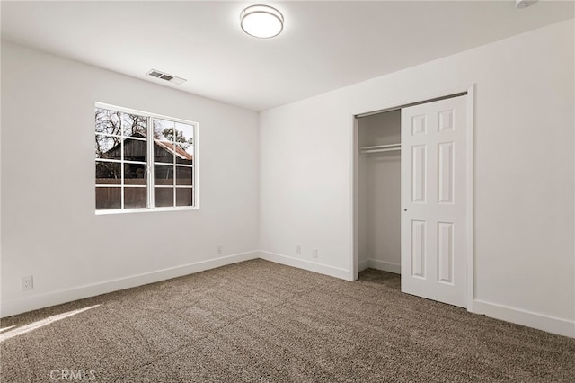 unfurnished bedroom featuring visible vents, baseboards, a closet, and carpet flooring