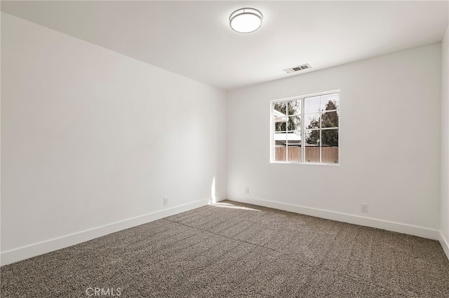 empty room featuring visible vents, baseboards, and carpet