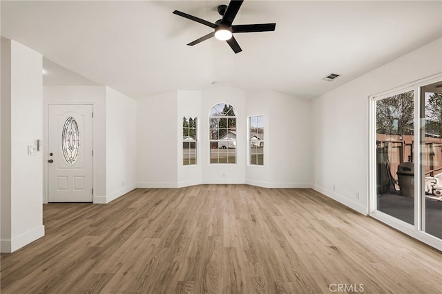 unfurnished room featuring vaulted ceiling, wood finished floors, visible vents, and a wealth of natural light