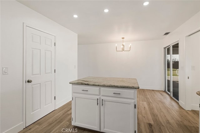 kitchen featuring visible vents, light wood-style flooring, recessed lighting, white cabinetry, and decorative light fixtures