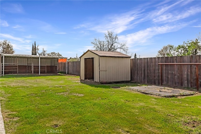 view of yard featuring a fenced backyard, an outbuilding, and a storage shed