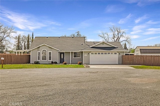 ranch-style home featuring an attached garage, fence, driveway, and a shingled roof