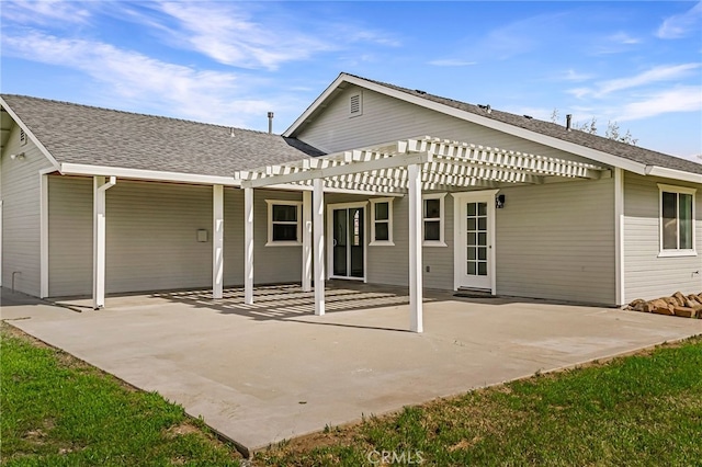 rear view of house with a patio area, a pergola, and roof with shingles