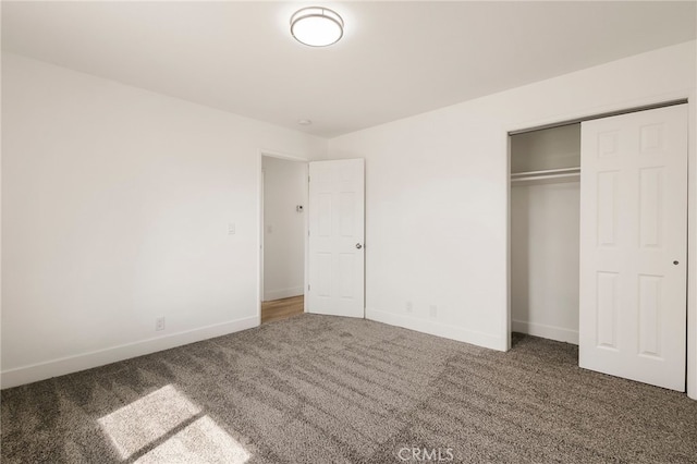 unfurnished bedroom with a closet, baseboards, and carpet floors