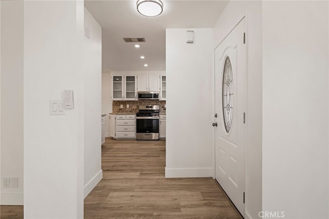 hall featuring recessed lighting, baseboards, visible vents, and light wood-type flooring