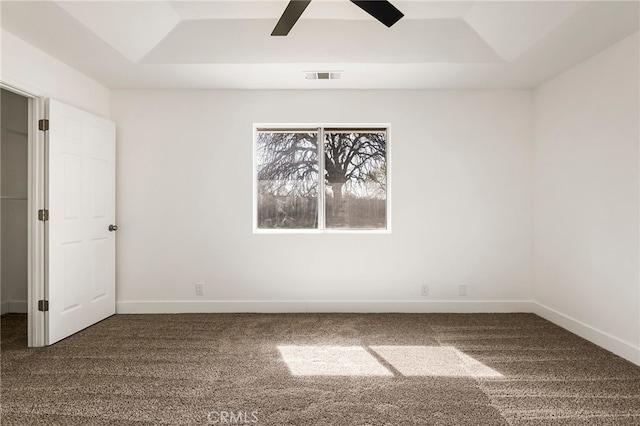 unfurnished bedroom featuring visible vents, carpet flooring, a raised ceiling, and baseboards