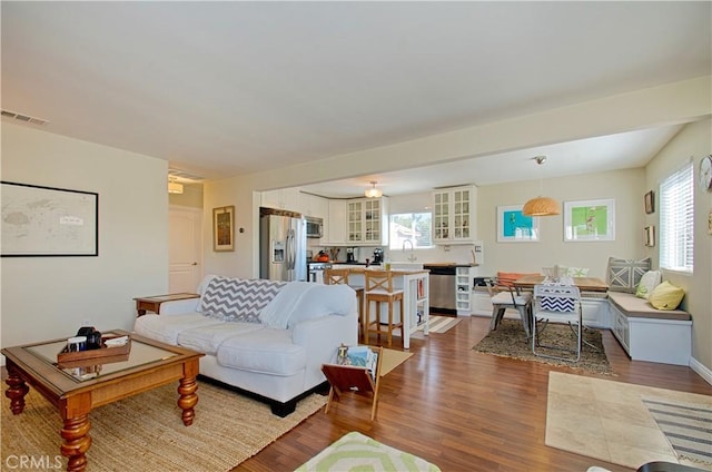 living room with visible vents and dark wood-style floors